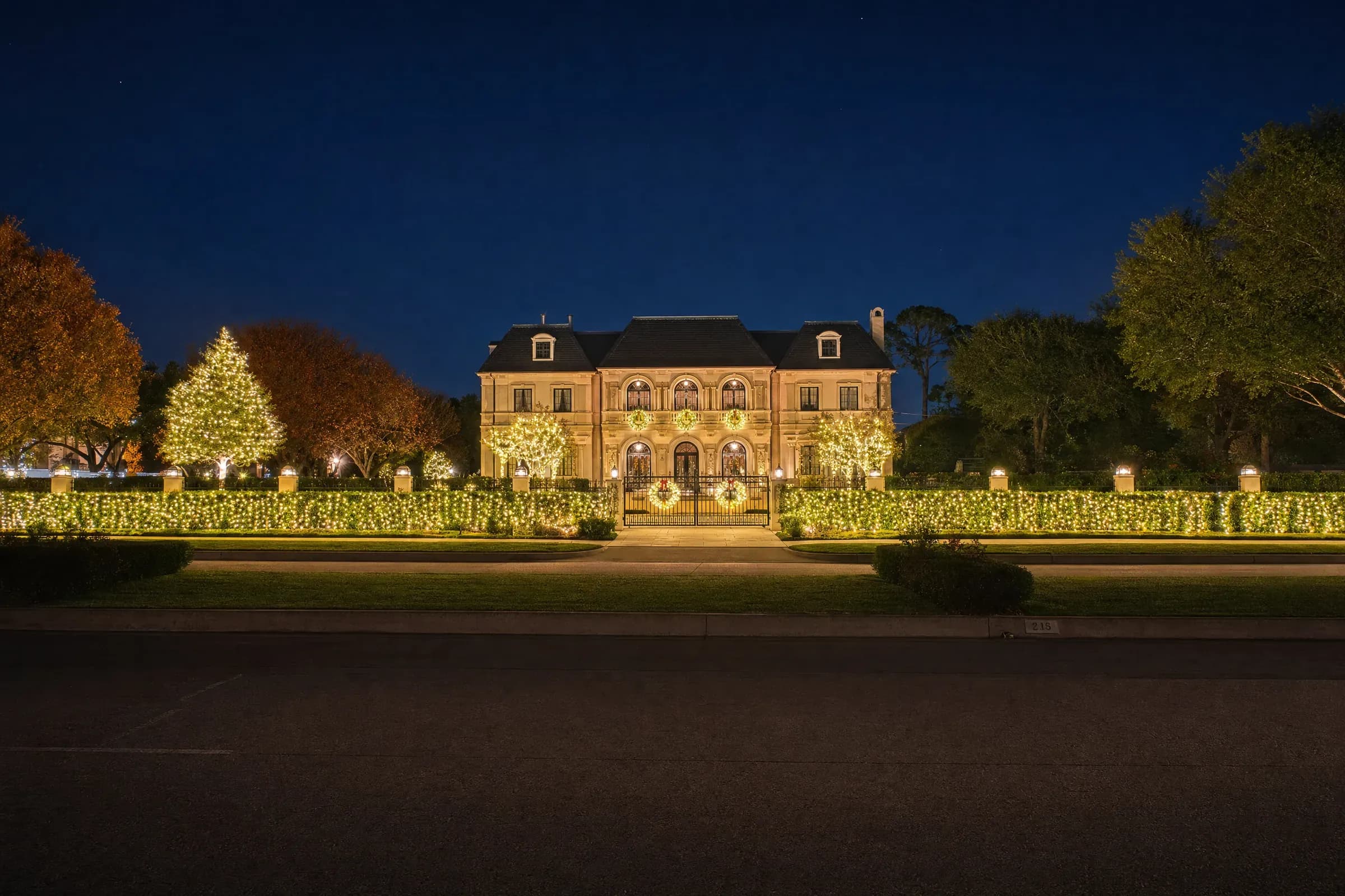 Grand River Oaks estate in Houston with warm-white Christmas lights and lit landscaping