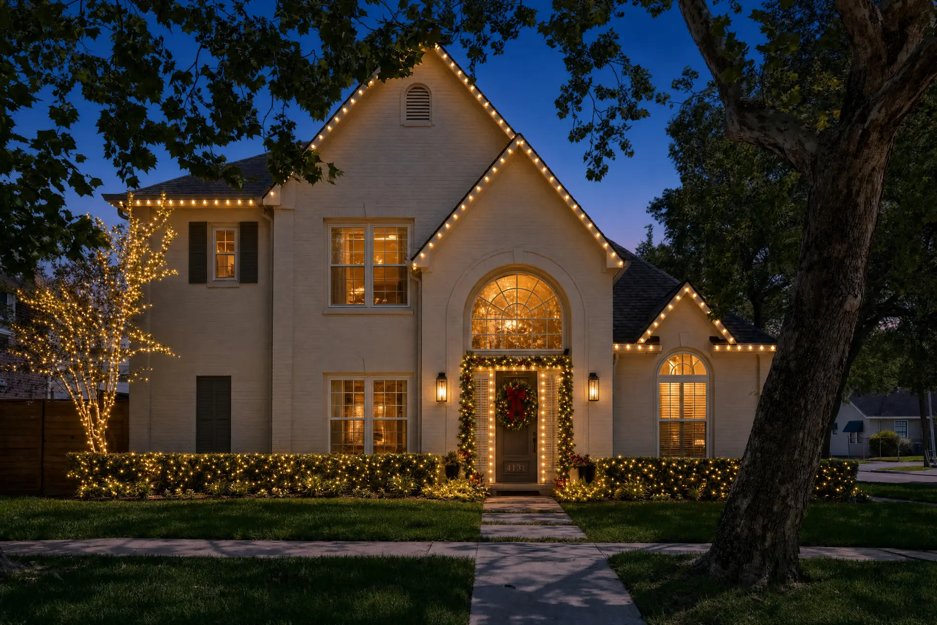 Two-story home in West University Place, Houston with warm-white roofline Christmas lights at night