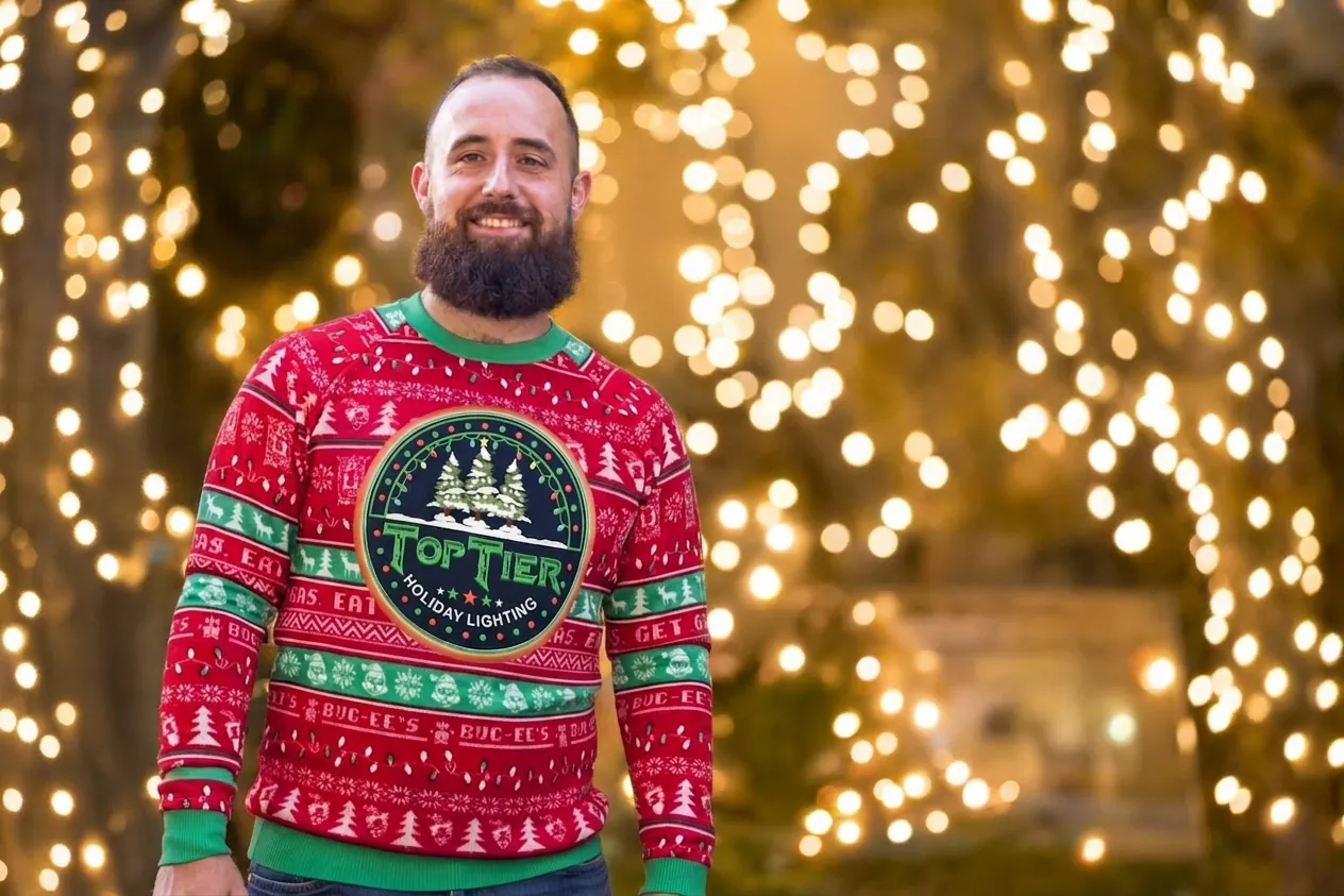 Amar, owner of Top Tier Lights, a West University-area Christmas light installer, in a Top Tier holiday sweater