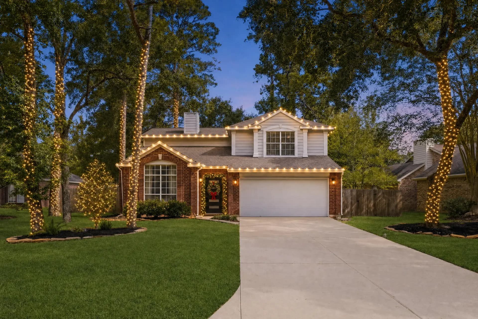 Professional Christmas lights glowing on a home in Spring, TX at night