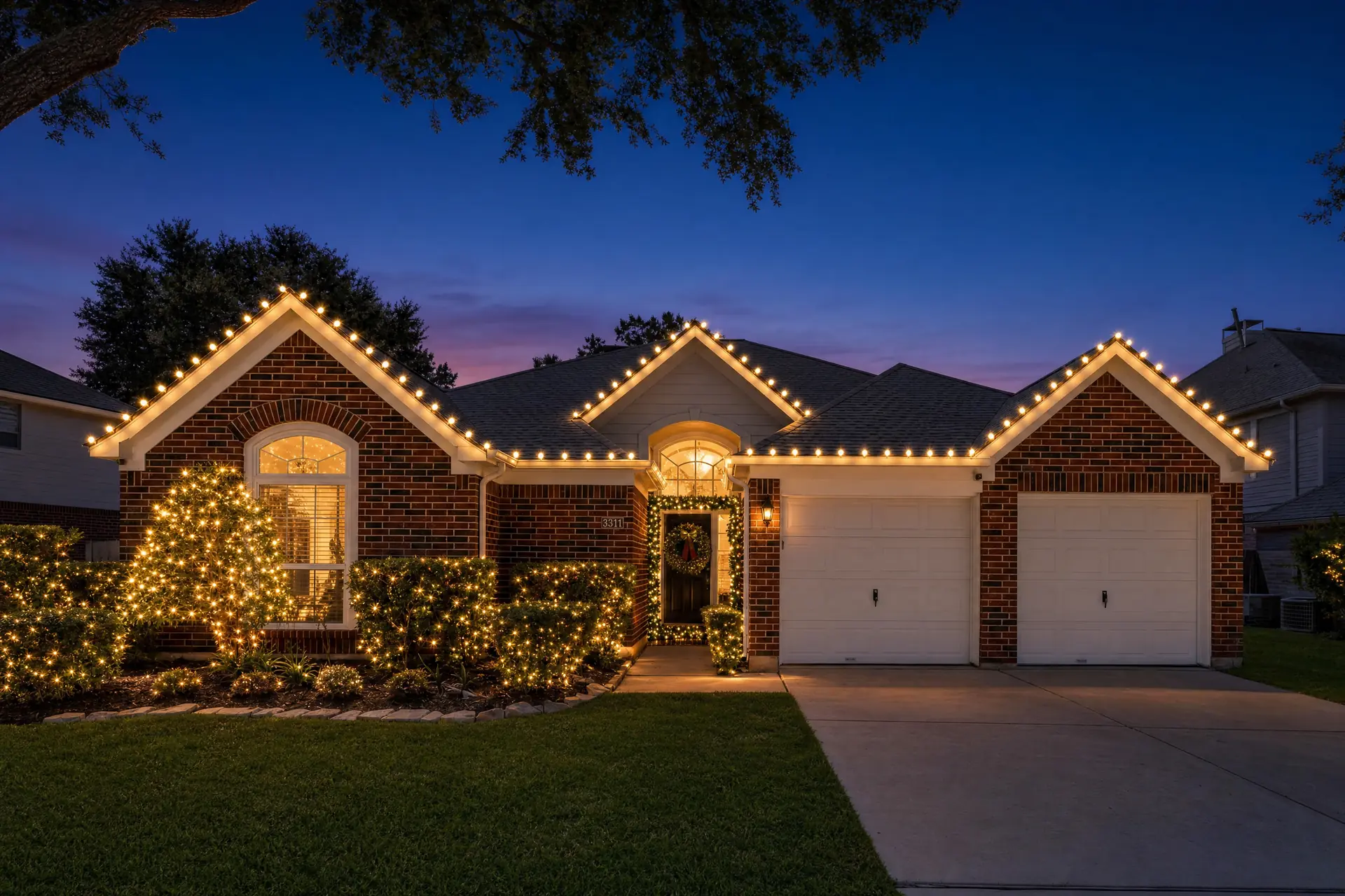 Two-story home in Cinco Ranch, Katy with warm-white roofline Christmas lights at night